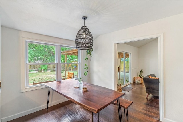 dining area featuring a healthy amount of sunlight, dark hardwood / wood-style flooring, and a chandelier