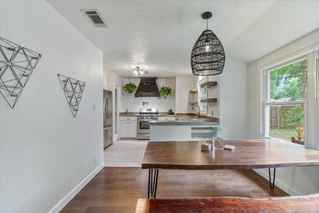 unfurnished dining area featuring sink, light wood-type flooring, and a notable chandelier