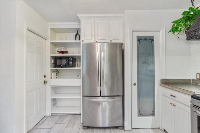 kitchen with white cabinets and stainless steel refrigerator