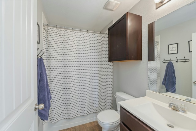 full bathroom featuring toilet, vanity, shower / tub combo with curtain, and hardwood / wood-style flooring