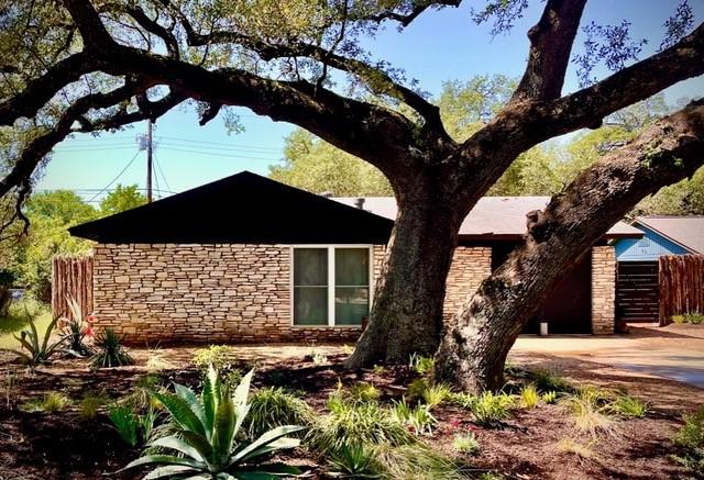 309 Rowland Dr, Austin, TX 78745 - view of side of home with stone siding and concrete driveway