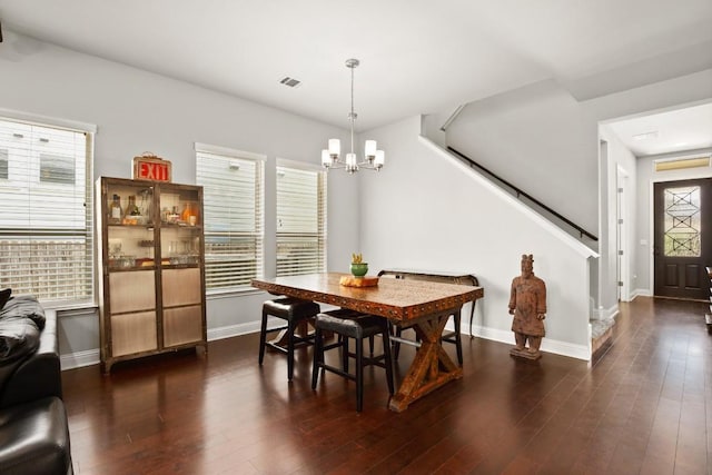 dining room featuring dark hardwood / wood-style flooring and a chandelier