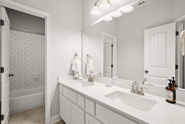 bathroom featuring tile patterned flooring, vanity, and tiled shower / bath