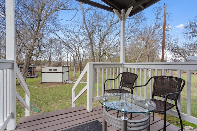 wooden terrace featuring a lawn and a storage shed