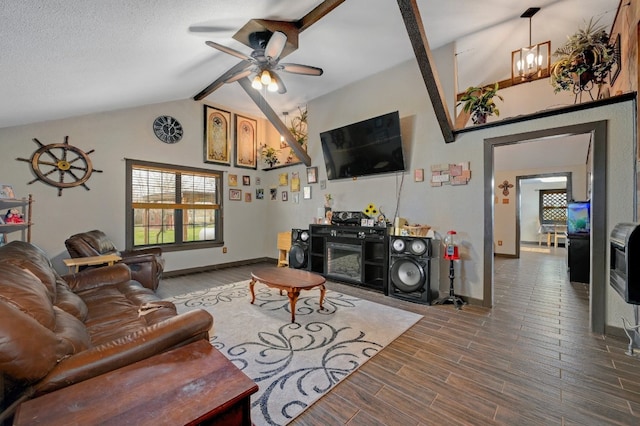 living room featuring a fireplace, ceiling fan with notable chandelier, lofted ceiling with beams, and heating unit