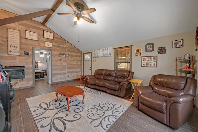 living room with a fireplace, lofted ceiling with beams, ceiling fan, and wooden walls