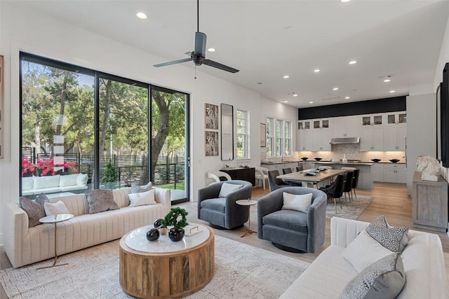 living room with light hardwood / wood-style flooring and ceiling fan