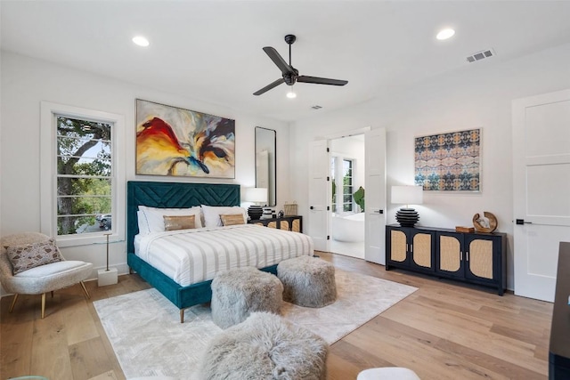 bedroom with ceiling fan, ensuite bathroom, and light wood-type flooring