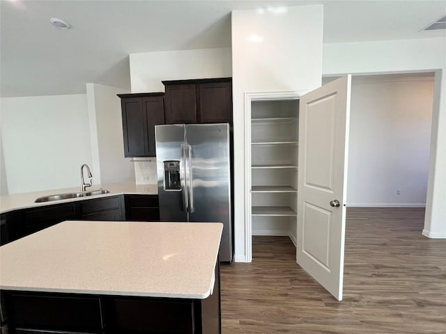 kitchen with sink, dark wood-type flooring, stainless steel refrigerator with ice dispenser, backsplash, and kitchen peninsula