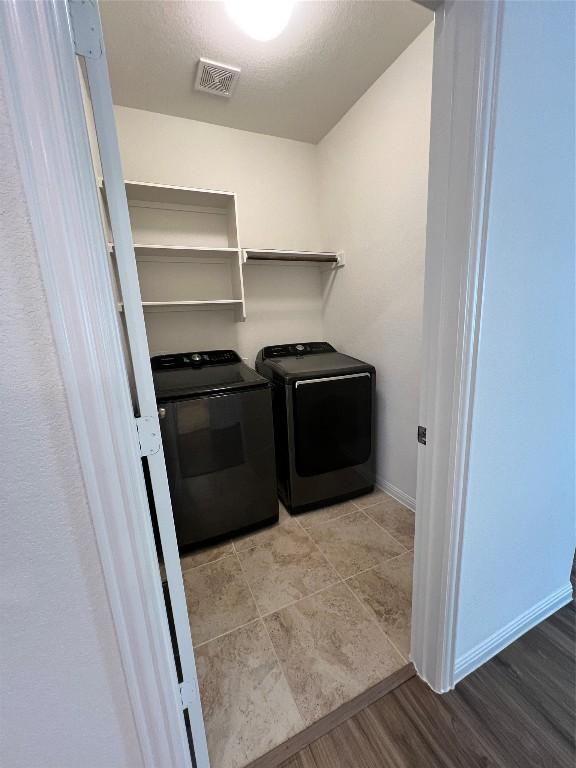 laundry room with washer and clothes dryer and light wood-type flooring