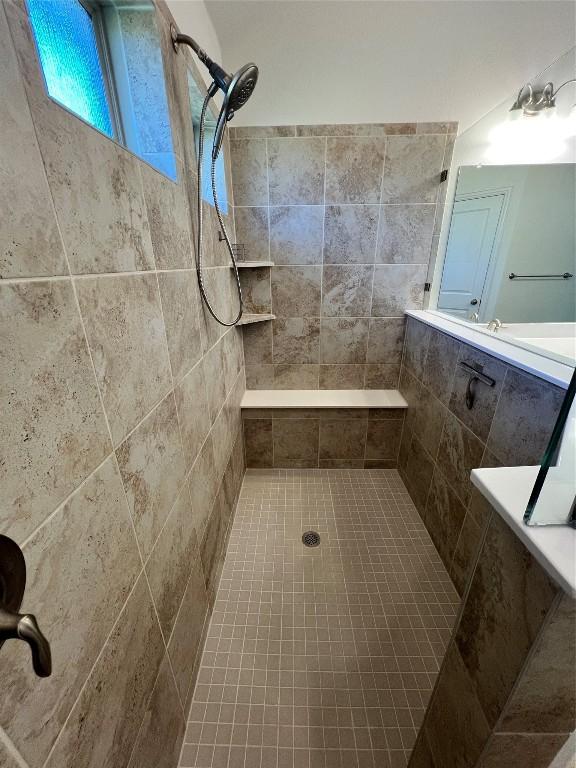 bathroom with tiled shower and tile patterned floors