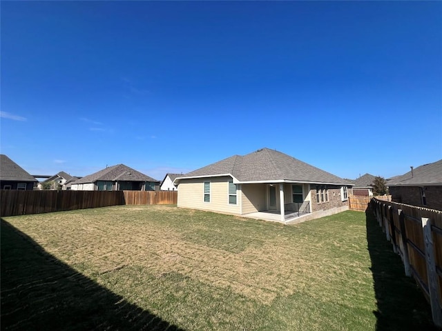 back of property with a lawn and a patio