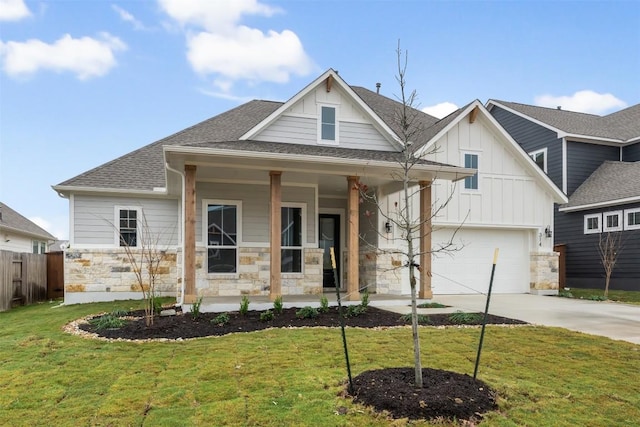 view of front of property with covered porch, a garage, and a front yard