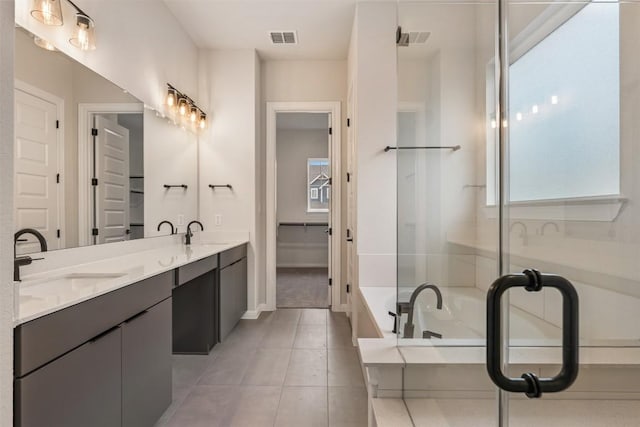 bathroom featuring vanity, a tub to relax in, and tile patterned floors