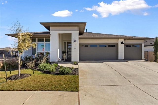 prairie-style home with a front yard and a garage