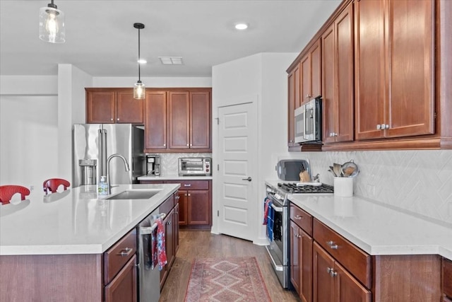 kitchen featuring pendant lighting, sink, tasteful backsplash, dark hardwood / wood-style flooring, and stainless steel appliances