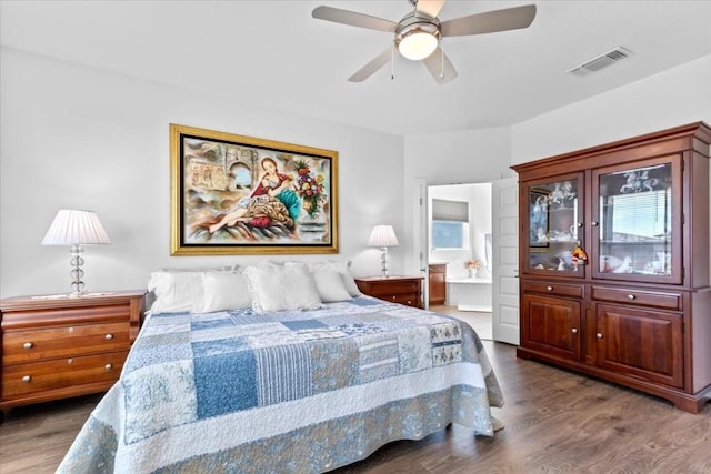 bedroom featuring connected bathroom, dark hardwood / wood-style floors, and ceiling fan