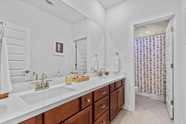 bathroom with tile patterned flooring, vanity, and toilet