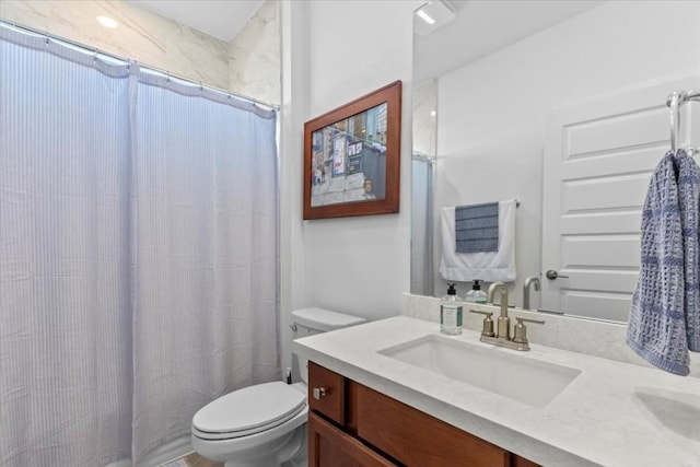 bathroom with walk in shower, vanity, and toilet