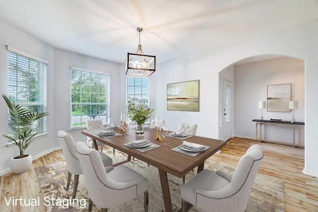 dining area featuring light hardwood / wood-style flooring and an inviting chandelier