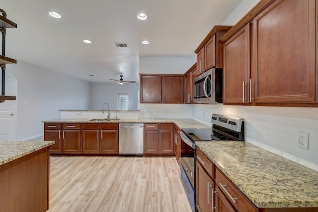 kitchen featuring tasteful backsplash, stainless steel appliances, ceiling fan, sink, and light hardwood / wood-style flooring