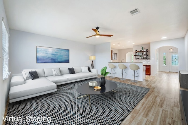 living room featuring ceiling fan and light hardwood / wood-style flooring