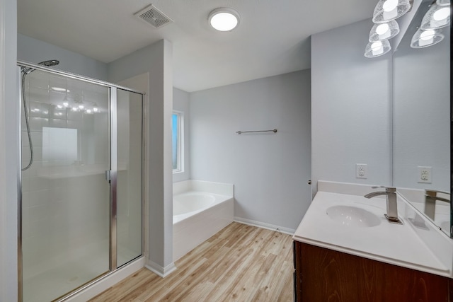 bathroom featuring vanity, plus walk in shower, and wood-type flooring