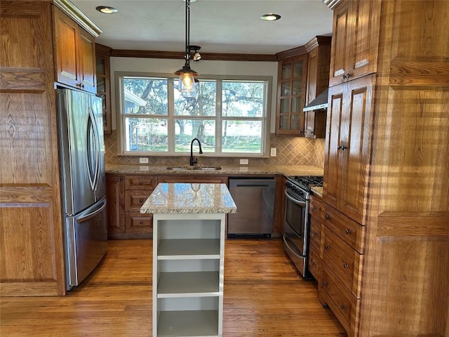 kitchen featuring sink, hanging light fixtures, decorative backsplash, light stone countertops, and stainless steel appliances