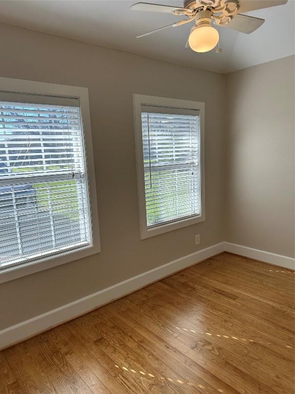 spare room with ceiling fan and light wood-type flooring