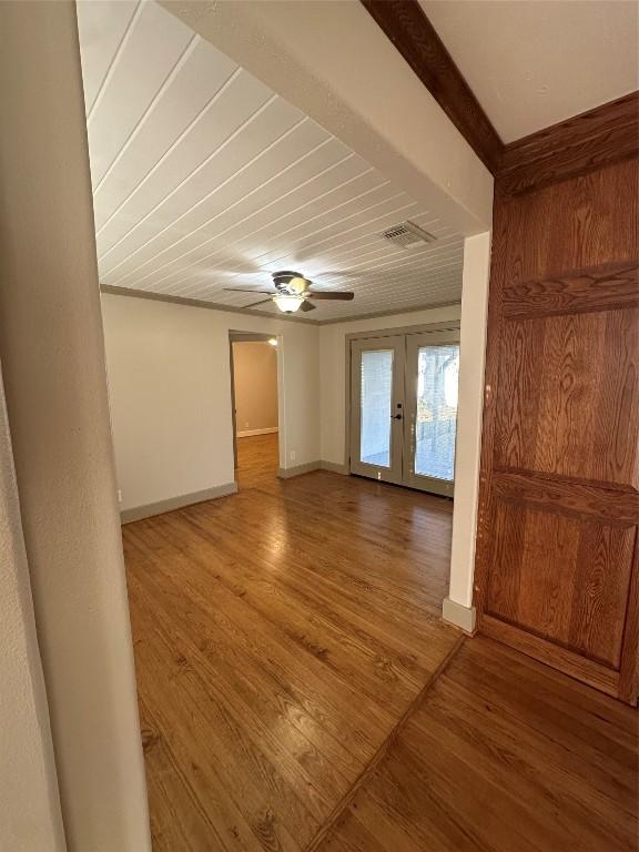 spare room with french doors, ceiling fan, ornamental molding, and wood-type flooring