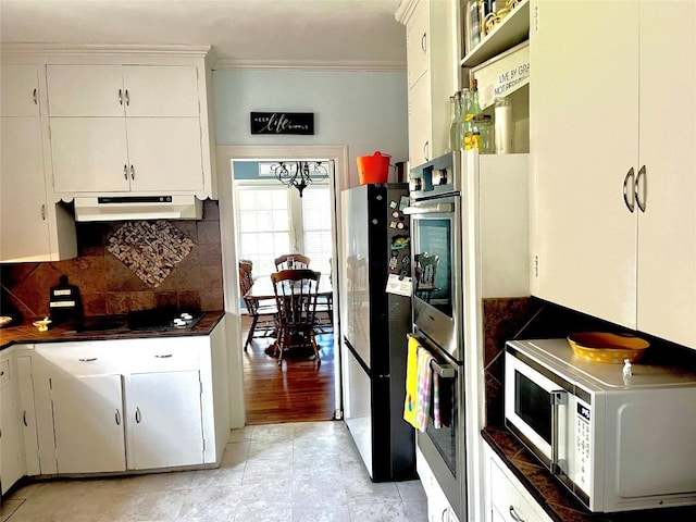 kitchen with backsplash, white cabinetry, crown molding, and stainless steel appliances