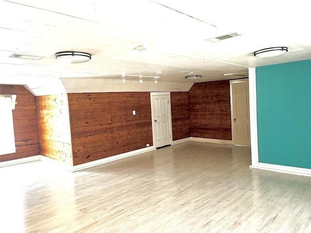 empty room with wood walls and wood-type flooring