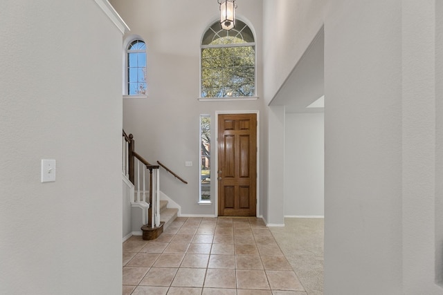 30004 Oakland Hills Dr, Georgetown, TX 78628 - foyer with light tile patterned floors, a high ceiling, and stairway