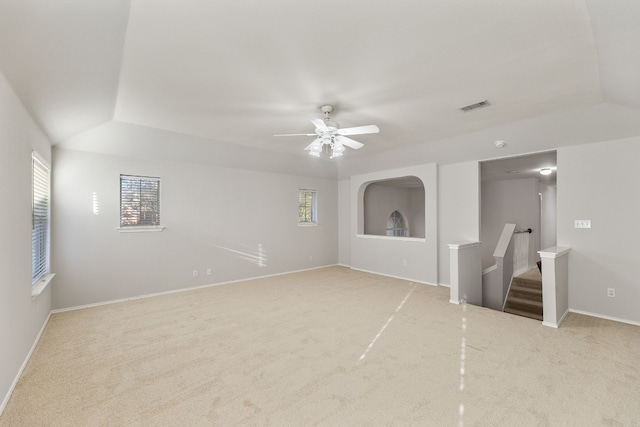 unfurnished room with a healthy amount of sunlight, ceiling fan, light colored carpet, and lofted ceiling