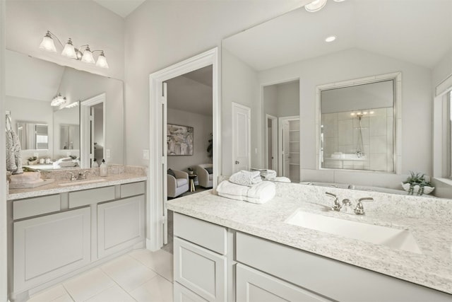 bathroom with tile patterned floors, vanity, tiled shower, and vaulted ceiling