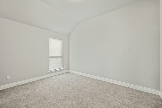 carpeted spare room with lofted ceiling