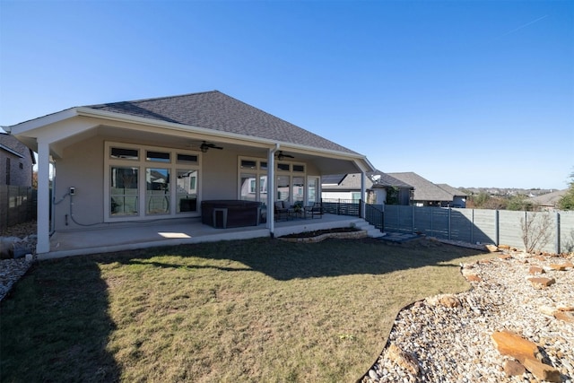 rear view of property with a lawn, a patio area, and ceiling fan