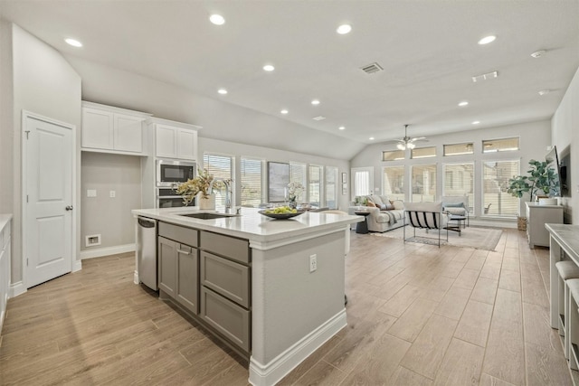 kitchen featuring stainless steel appliances, ceiling fan, a kitchen island with sink, sink, and white cabinetry