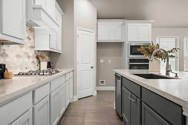 kitchen with white cabinetry, sink, premium range hood, and appliances with stainless steel finishes