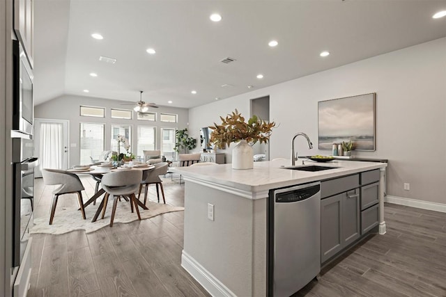 kitchen featuring sink, dark hardwood / wood-style flooring, gray cabinets, dishwasher, and a kitchen island with sink