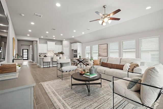 living room with vaulted ceiling and ceiling fan