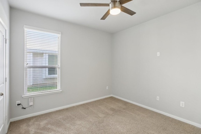 carpeted spare room with ceiling fan