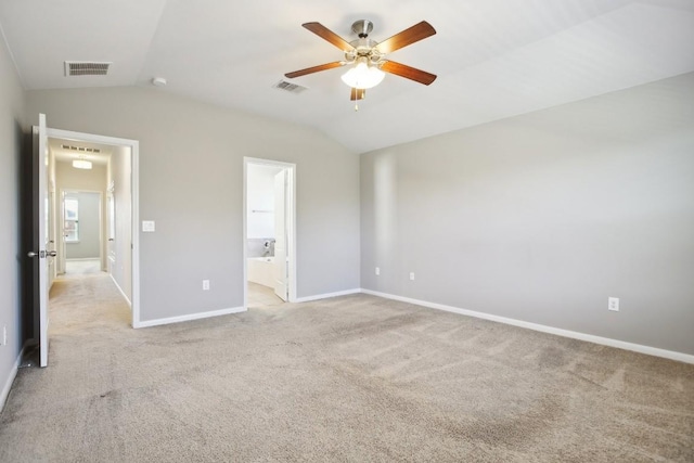 unfurnished bedroom with ensuite bathroom, ceiling fan, light colored carpet, and vaulted ceiling