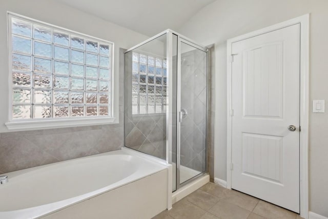 bathroom with tile patterned flooring, separate shower and tub, and lofted ceiling