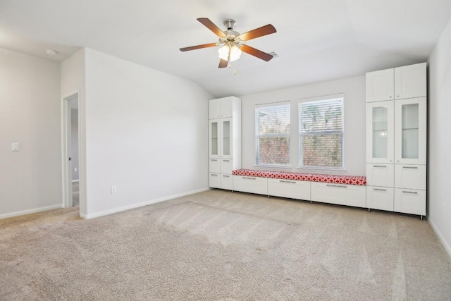 empty room featuring light carpet, ceiling fan, and lofted ceiling