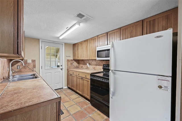 kitchen with white appliances, sink, a textured ceiling, tasteful backsplash, and light tile patterned flooring