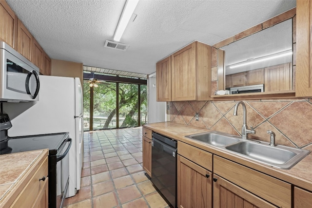 kitchen with floor to ceiling windows, sink, backsplash, a textured ceiling, and black appliances