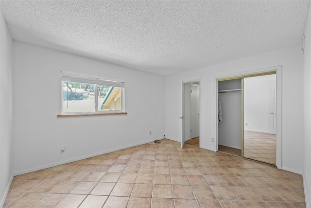 unfurnished bedroom with a textured ceiling and light tile patterned flooring