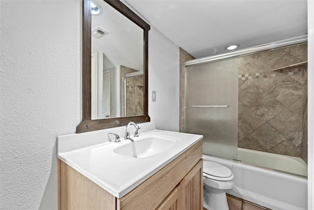 full bathroom with vanity, toilet, and shower / bath combination with glass door