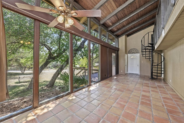 unfurnished sunroom featuring vaulted ceiling with beams, ceiling fan, a healthy amount of sunlight, and wood ceiling